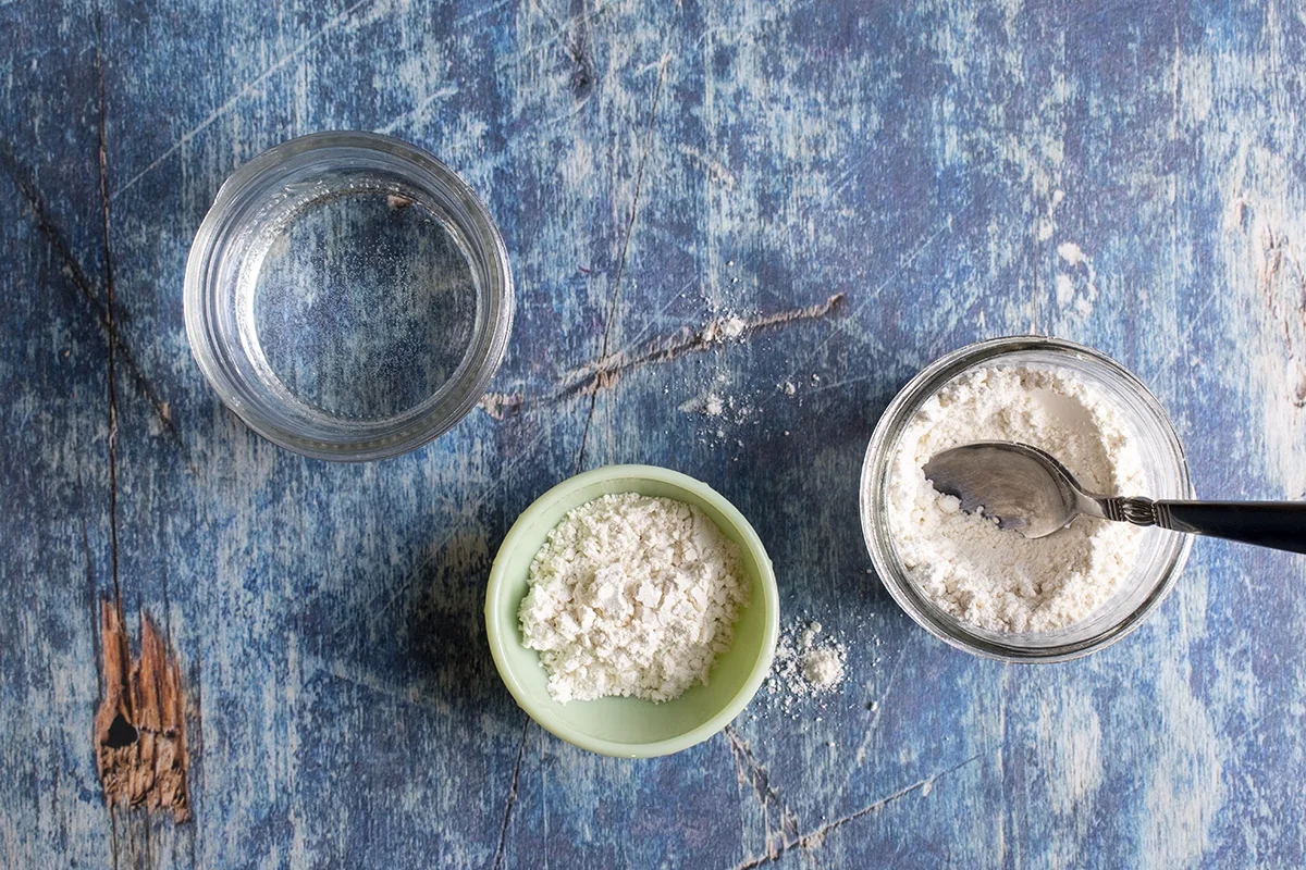 A cup of water a cup of flour and a small mixing dish