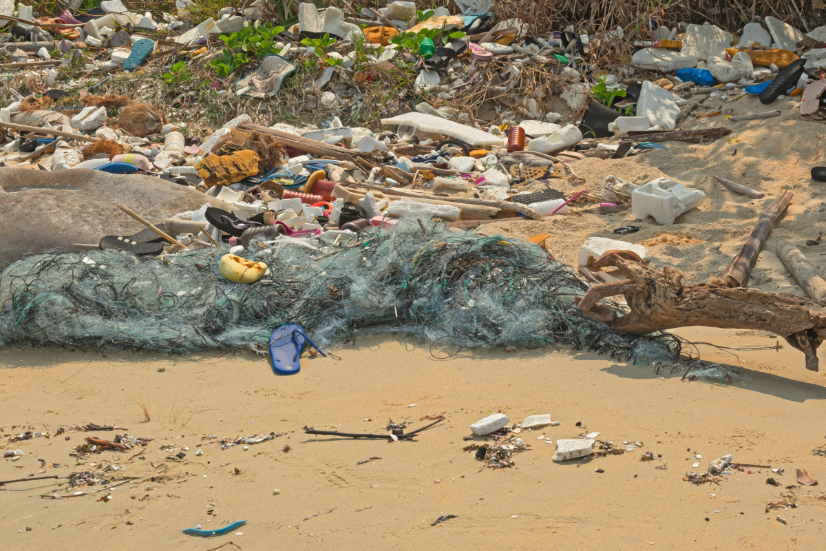 Plastic waste and fishing nets littering a beach. 