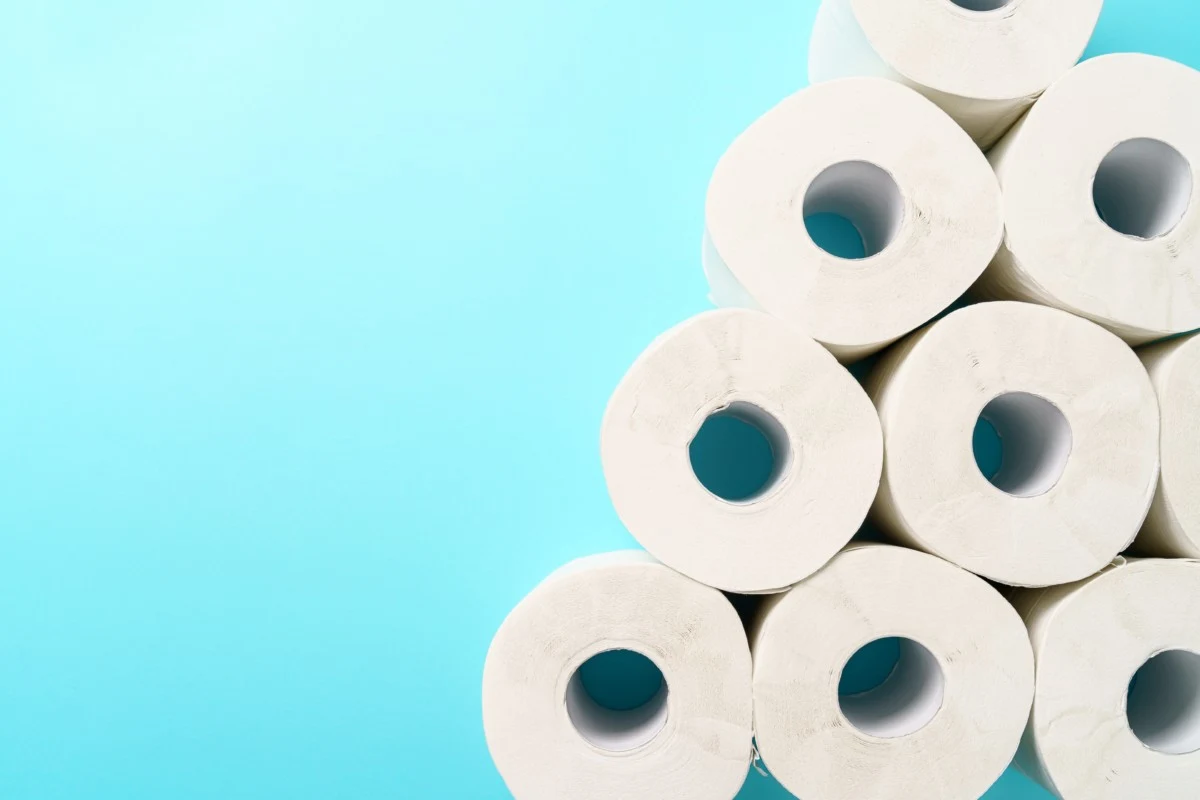 Several rows of toilet paper stacked against a blue background. 