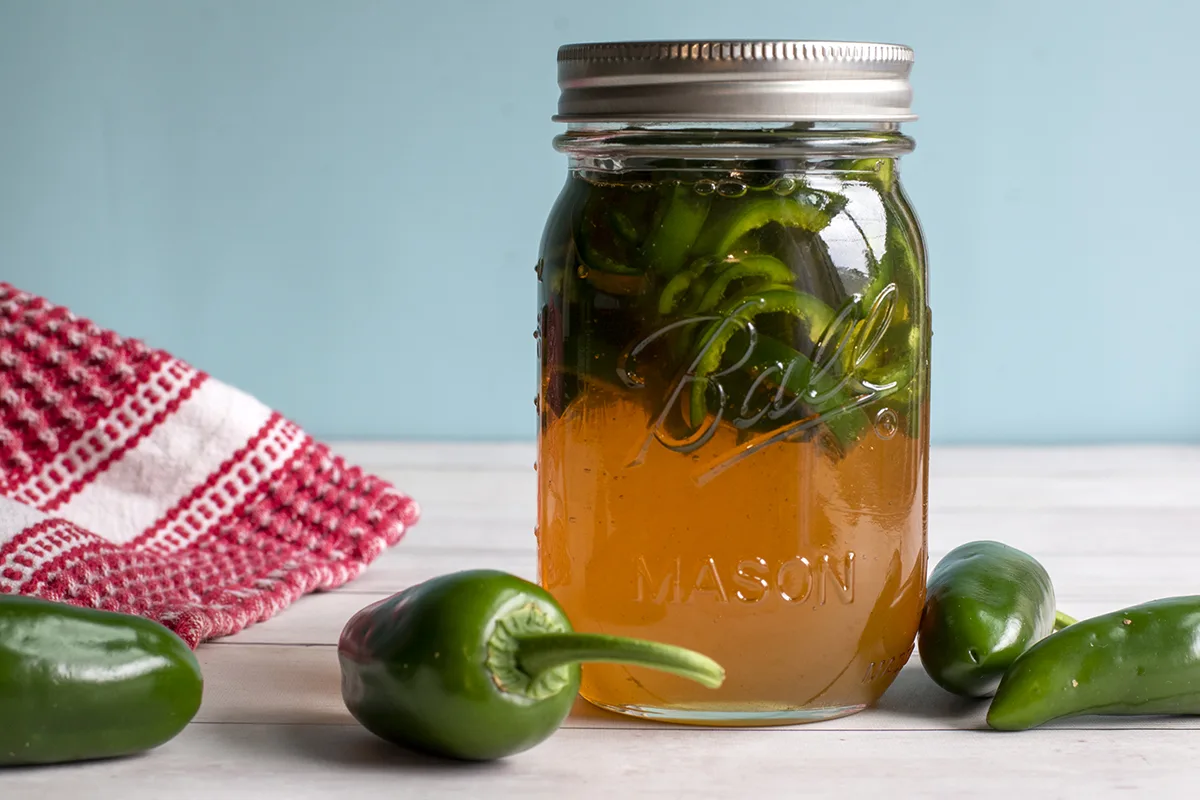 Mason jar with freshly chopped jalapenos and honey