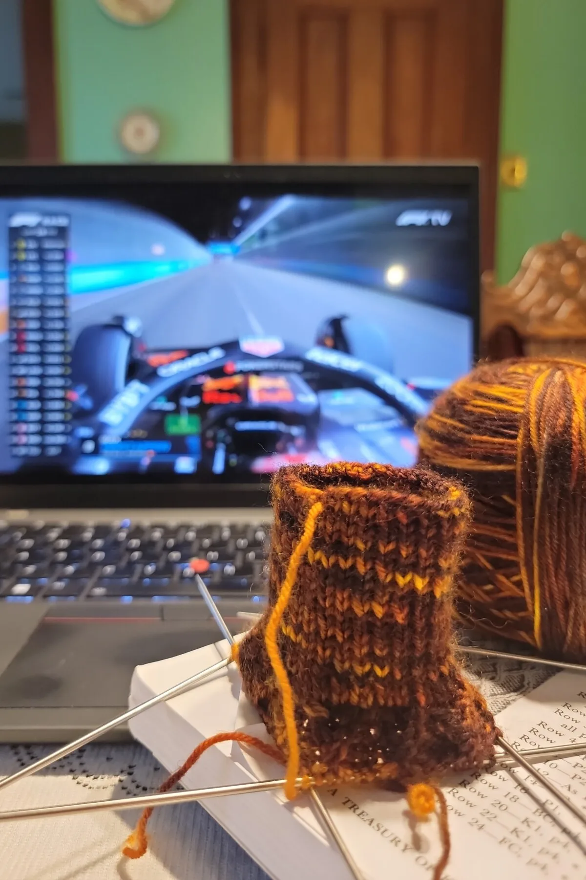 Knitting and laptop displaying F1 race