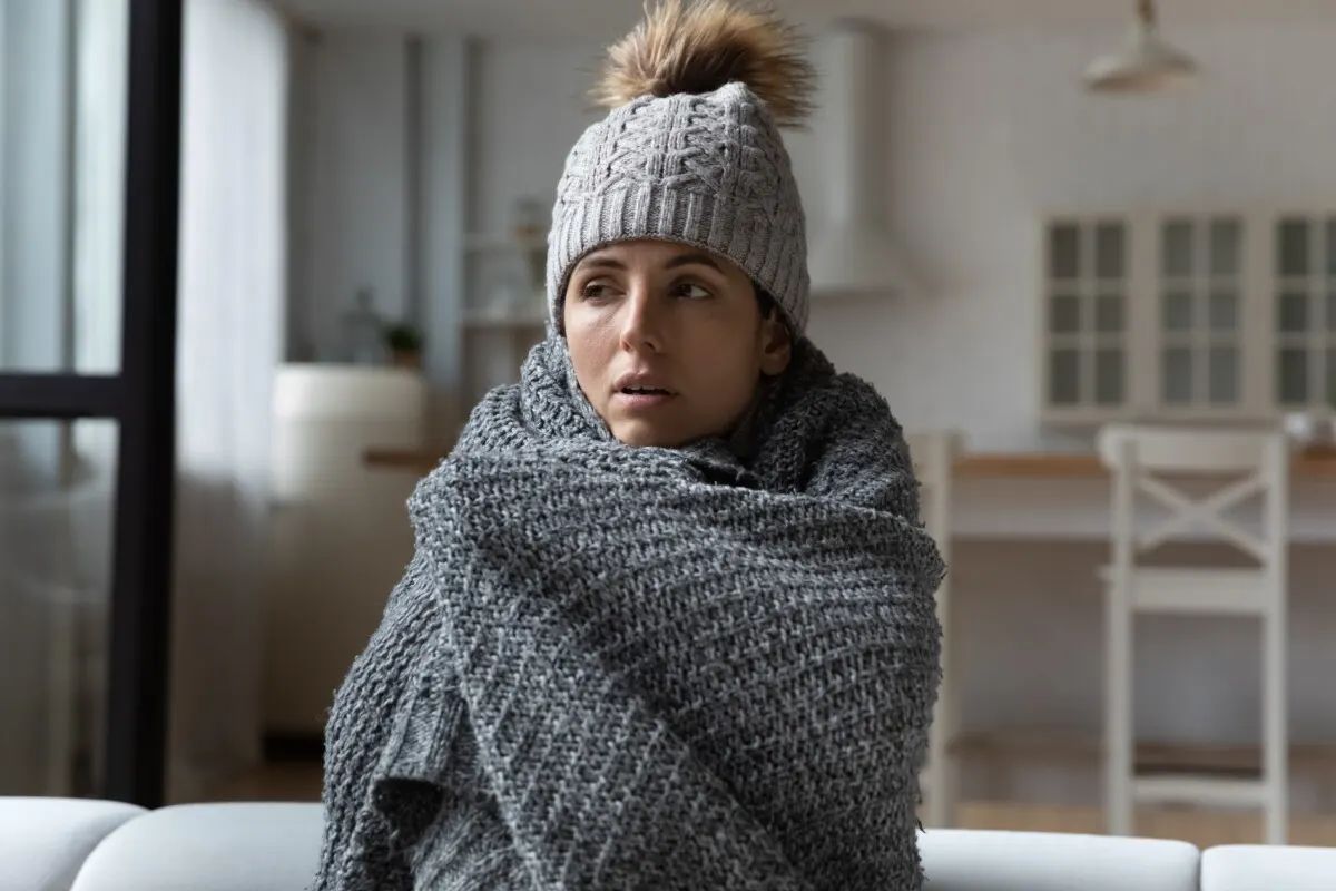 Woman bundled up indoors.