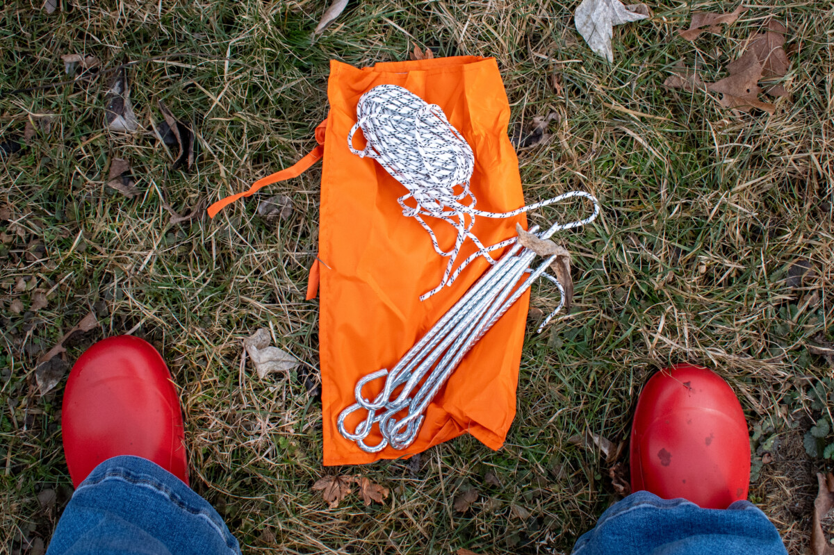 woman's feet with tent stakes and rope between them on the ground