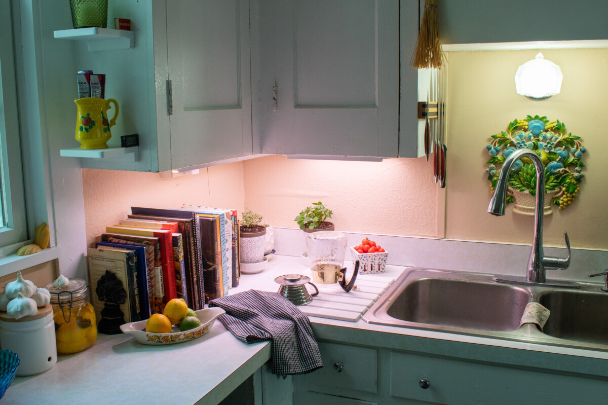 Kitchen sink and counters lit by grow lights