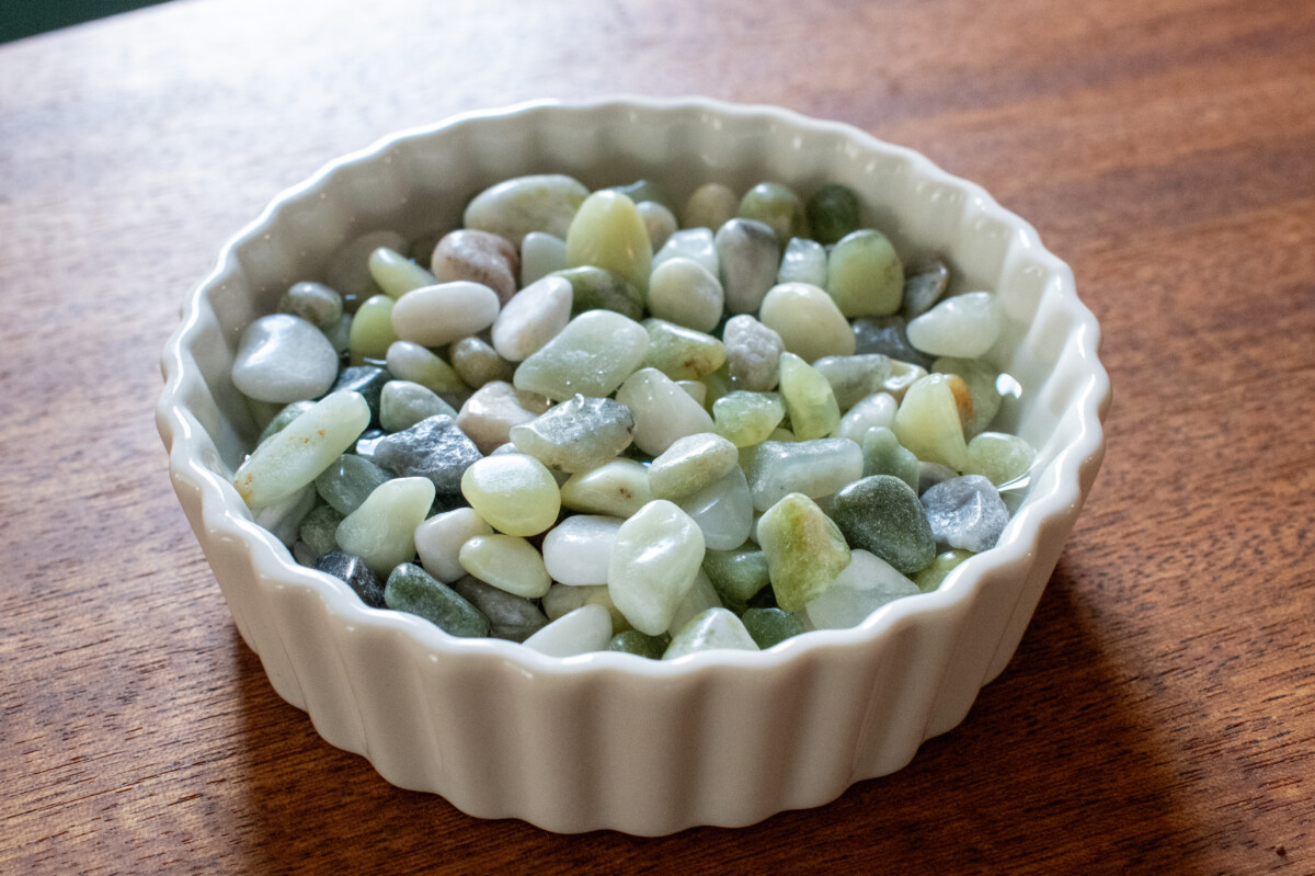 White ceramic ramekin filled with jade chips